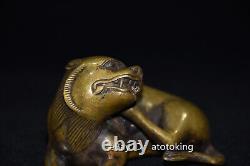 4 Antiquités chinoises en cuivre jaune : Statue d'un lion en position agenouillée regardant en arrière.